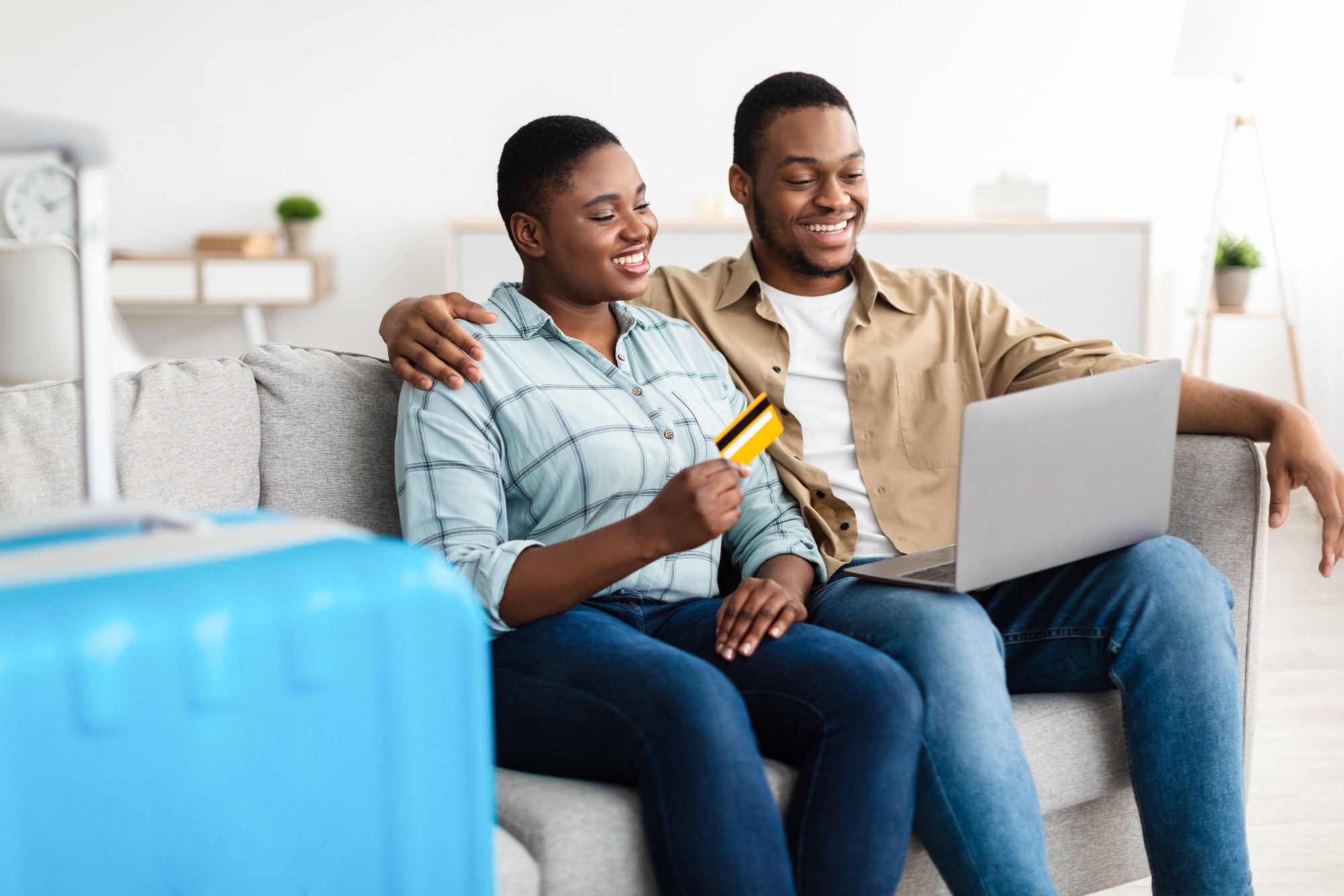 African Couple Booking Flight With Laptop And Credit Card Indoor